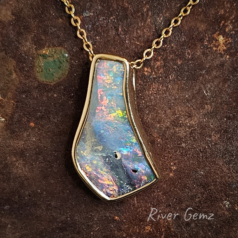 Fire boulder opal besel set in high grade gold necklace.