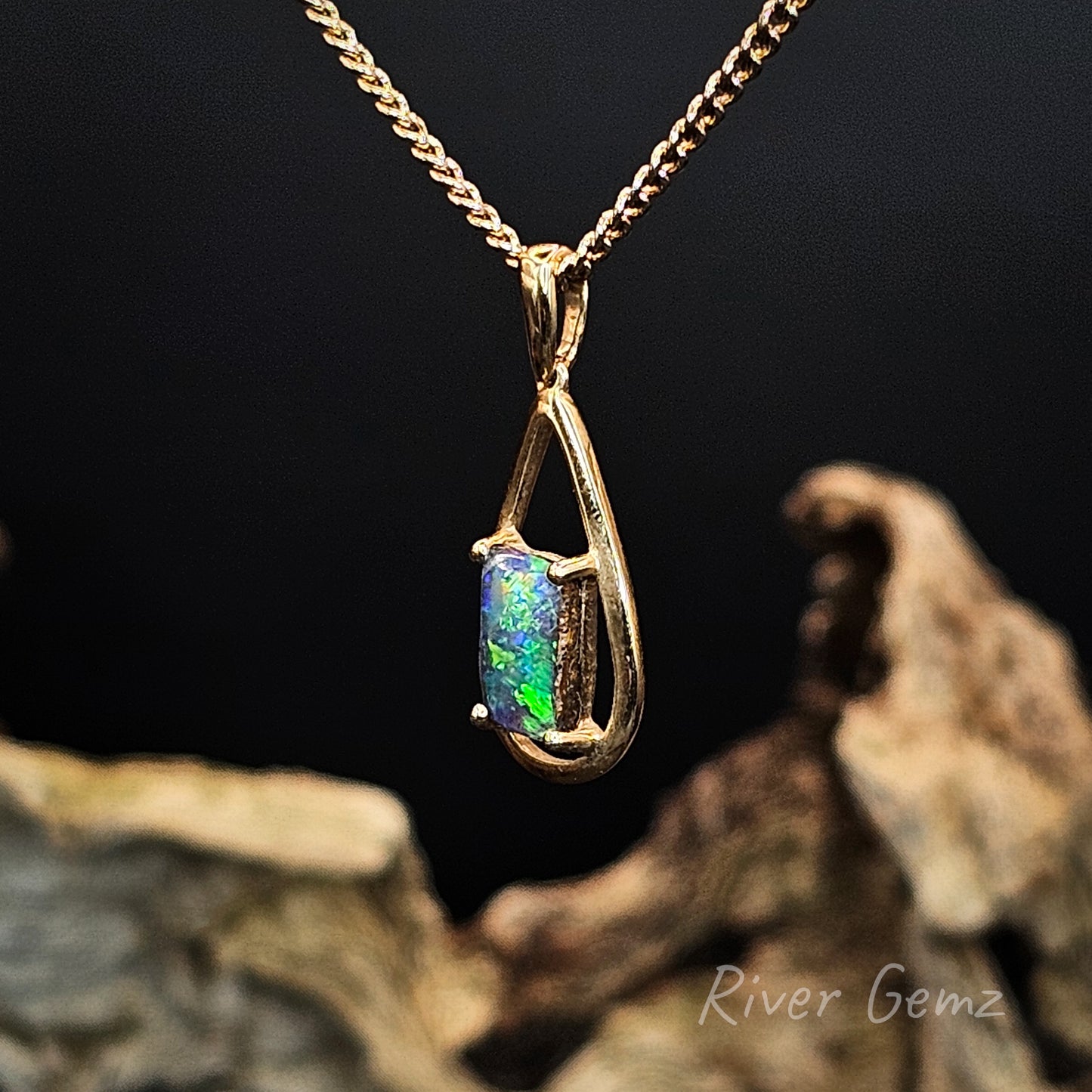 Opal pendant necklace on a gold chain with a dark background and 'River Gemz' branding.