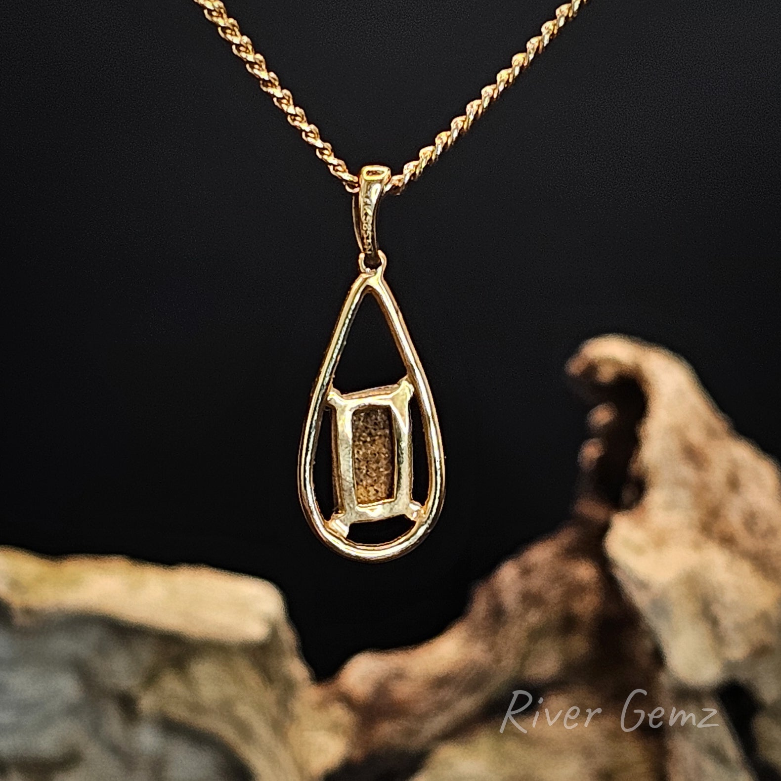 Back of gold necklace showing the ironstone matrix of the boulder opal set in it.