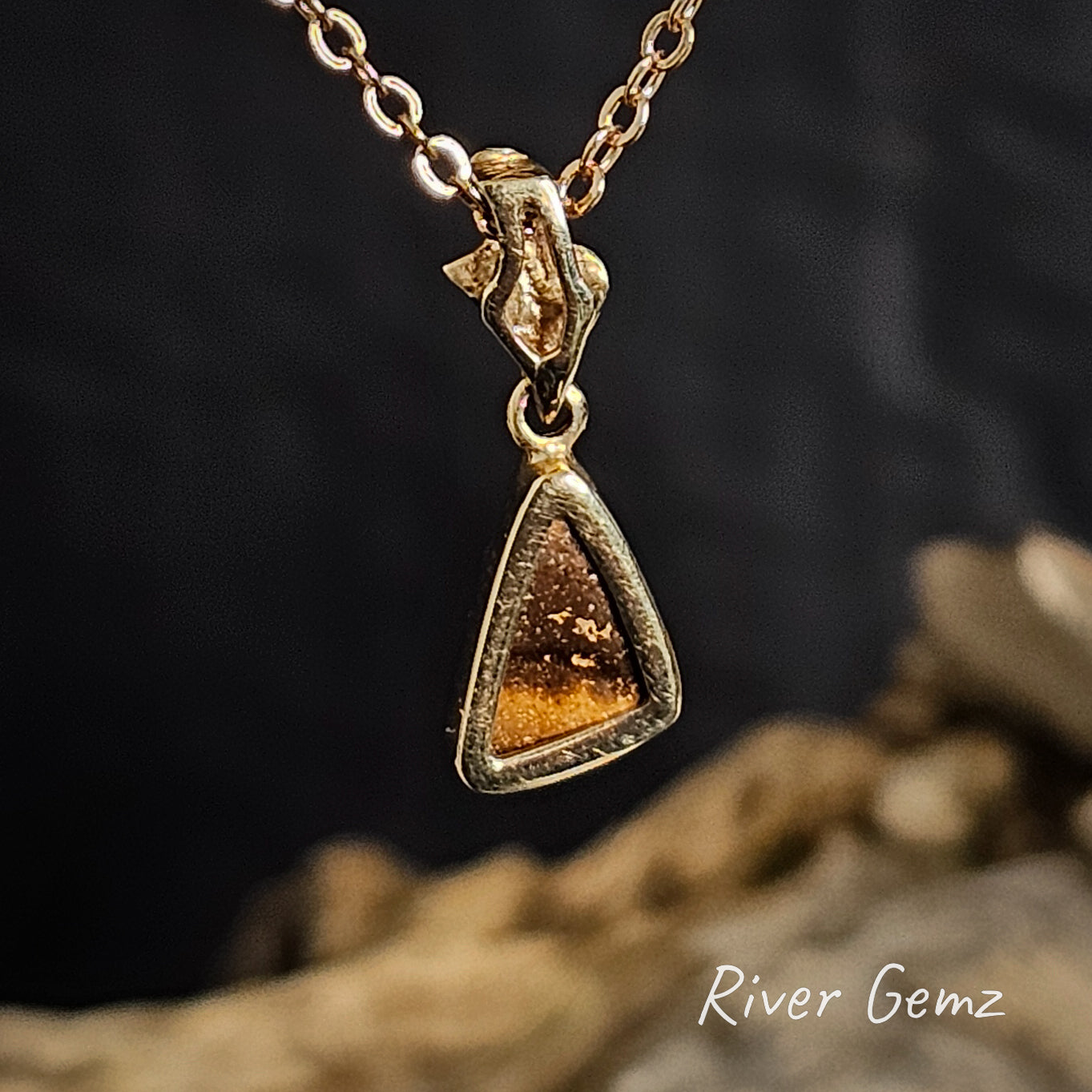 Rear of the gold pendant shows the ironstone matrix of the boulder opal, set against a dark background with 'River Gemz' branding.