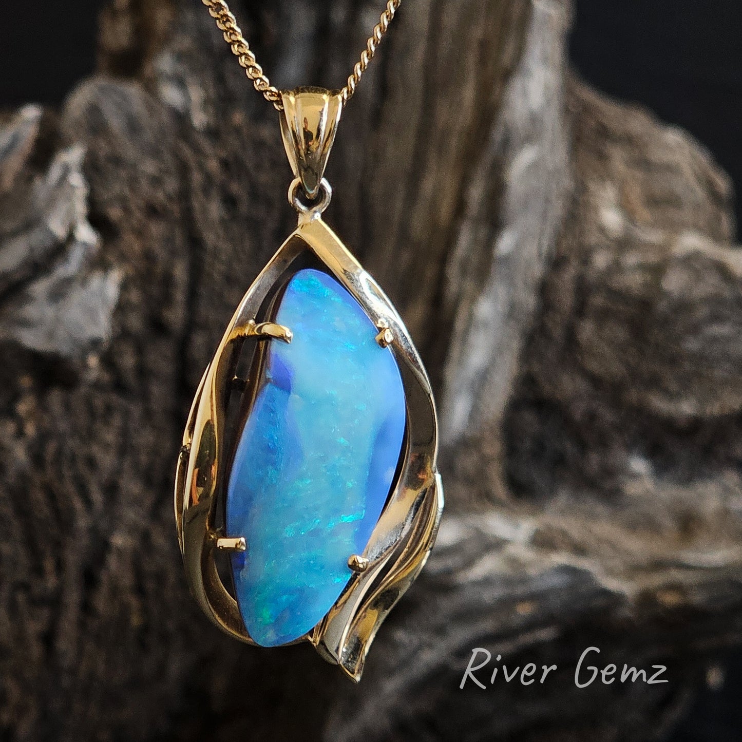 Large blue Queensland boulder opal claw set in a yellow gold necklace.