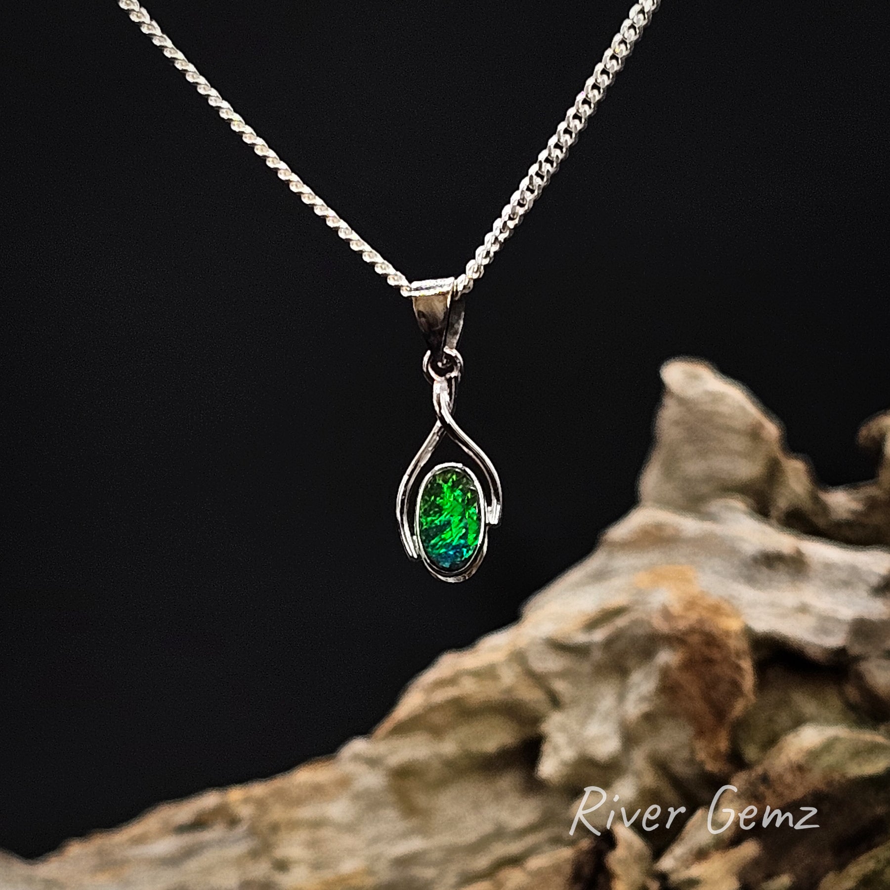 Oval shaped green boulder opal besel set in white gold necklace.