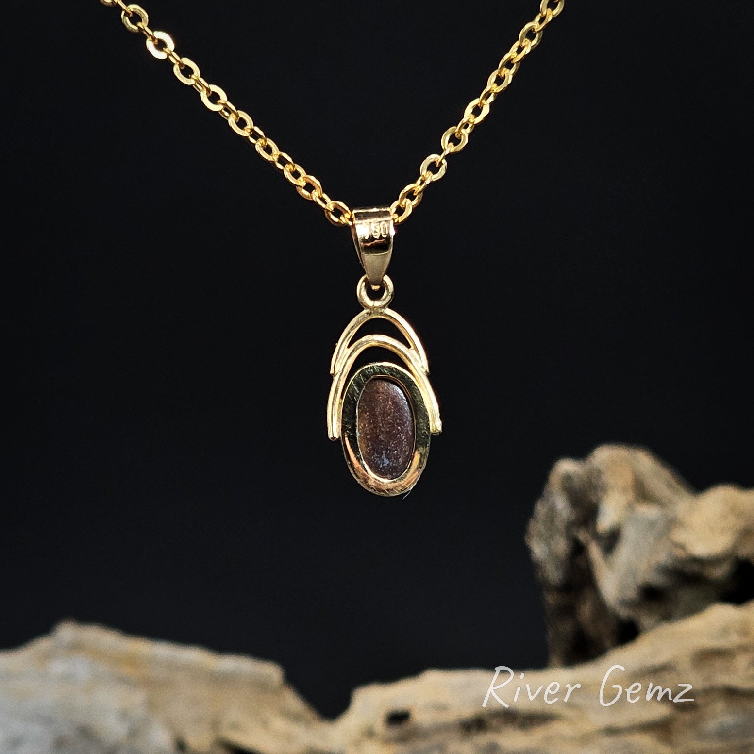 Back view of gold necklace shows the ironstone matrix of the boulder opal on a dark background