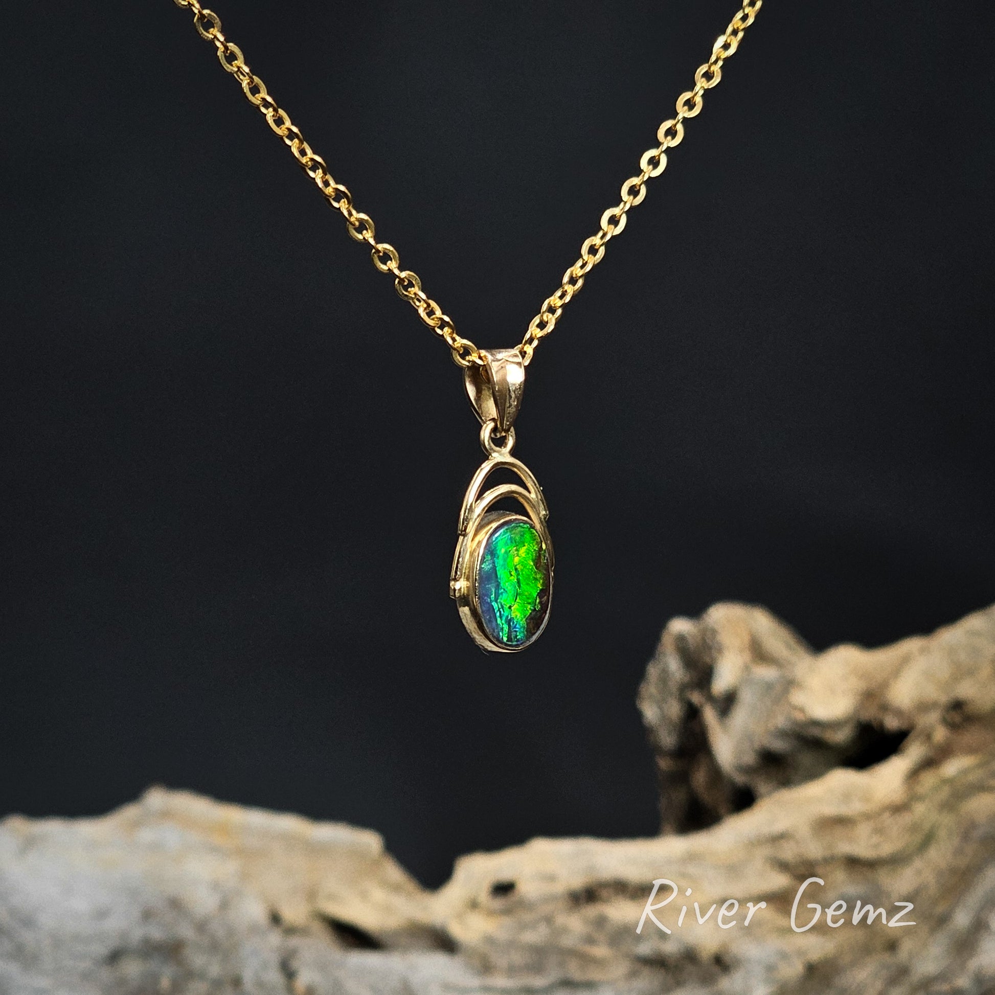Green opal besel set in yellow gold pendant on a dark background