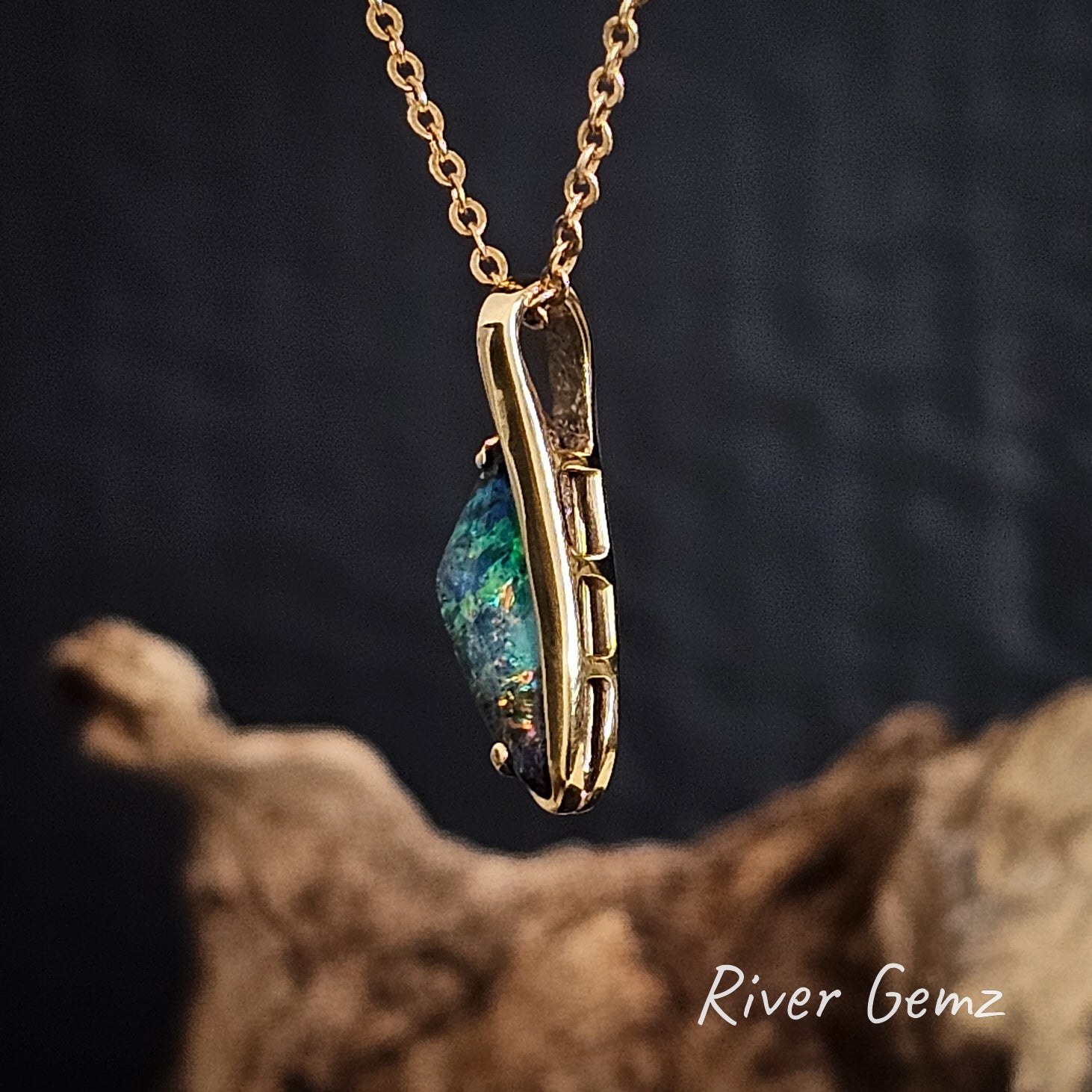 Side view of the gold necklace shows the lattice work of the setting and the hidden bail.