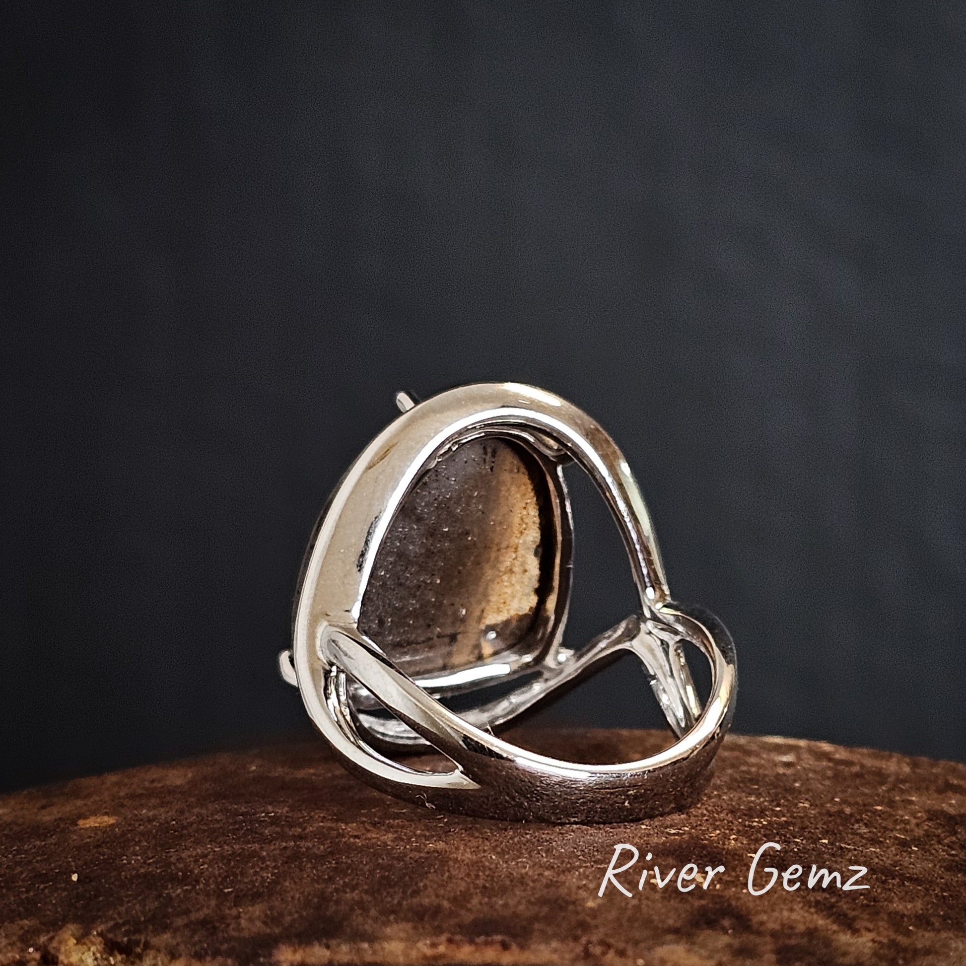 Rear of white gold ring showing the ironstone base of the embedded boulder opal on a dark background, featuring 'River Gemz' branding.