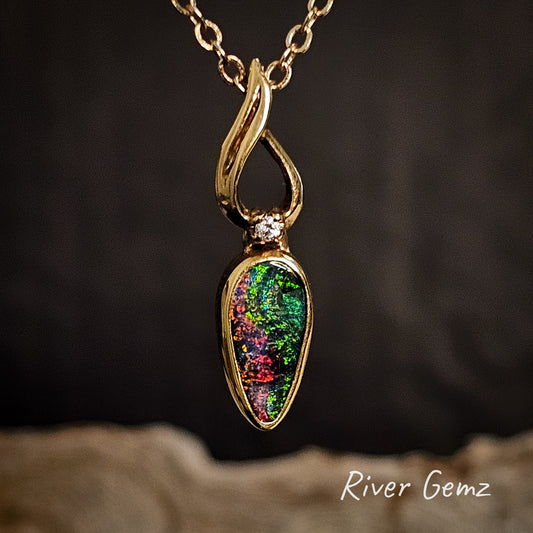 Gold pendant with a diamond and a red and green boulder opal on a dark background, featuring 'River Gemz' branding.