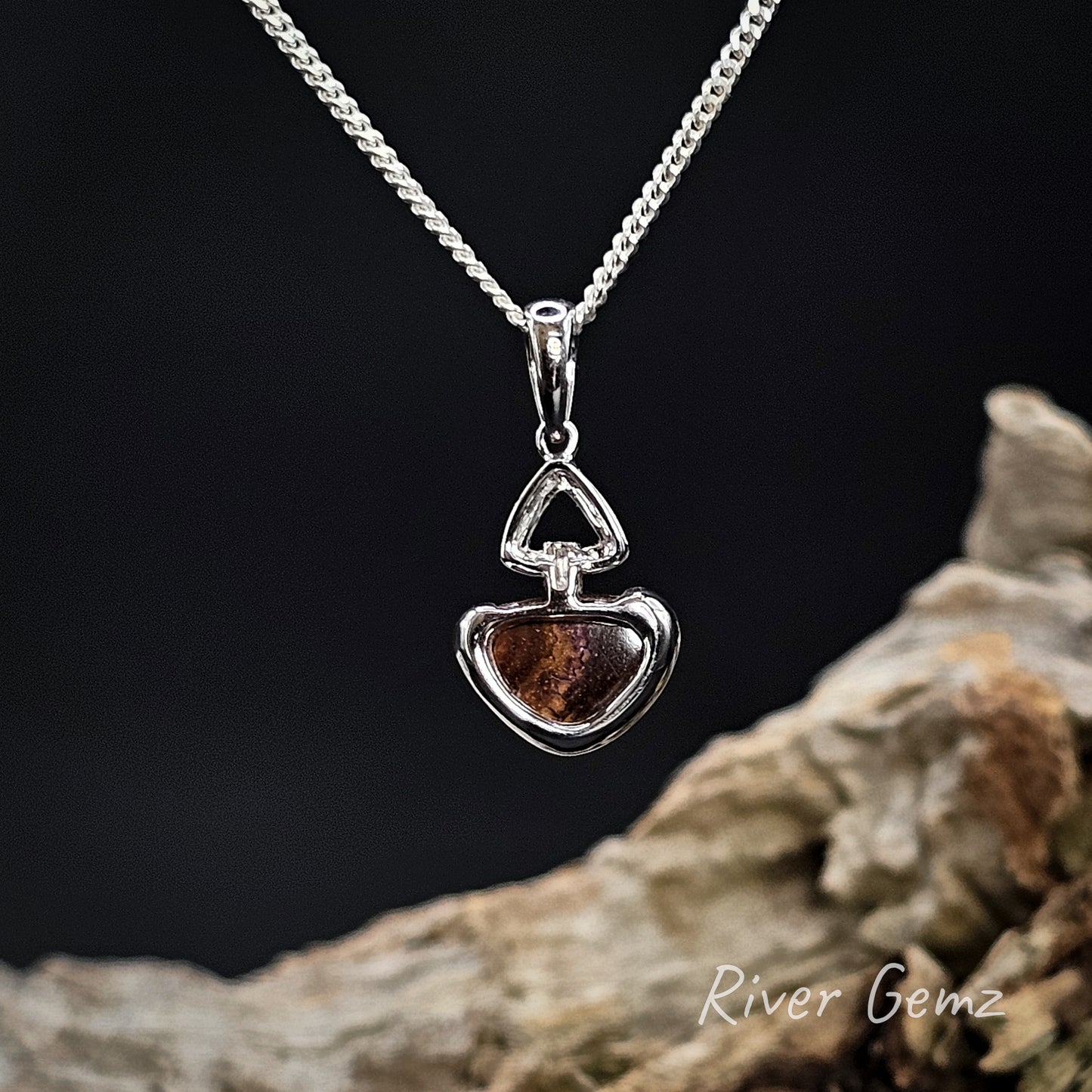 Rear view of necklaces pendant showing the brown base tone of the boulder opal.