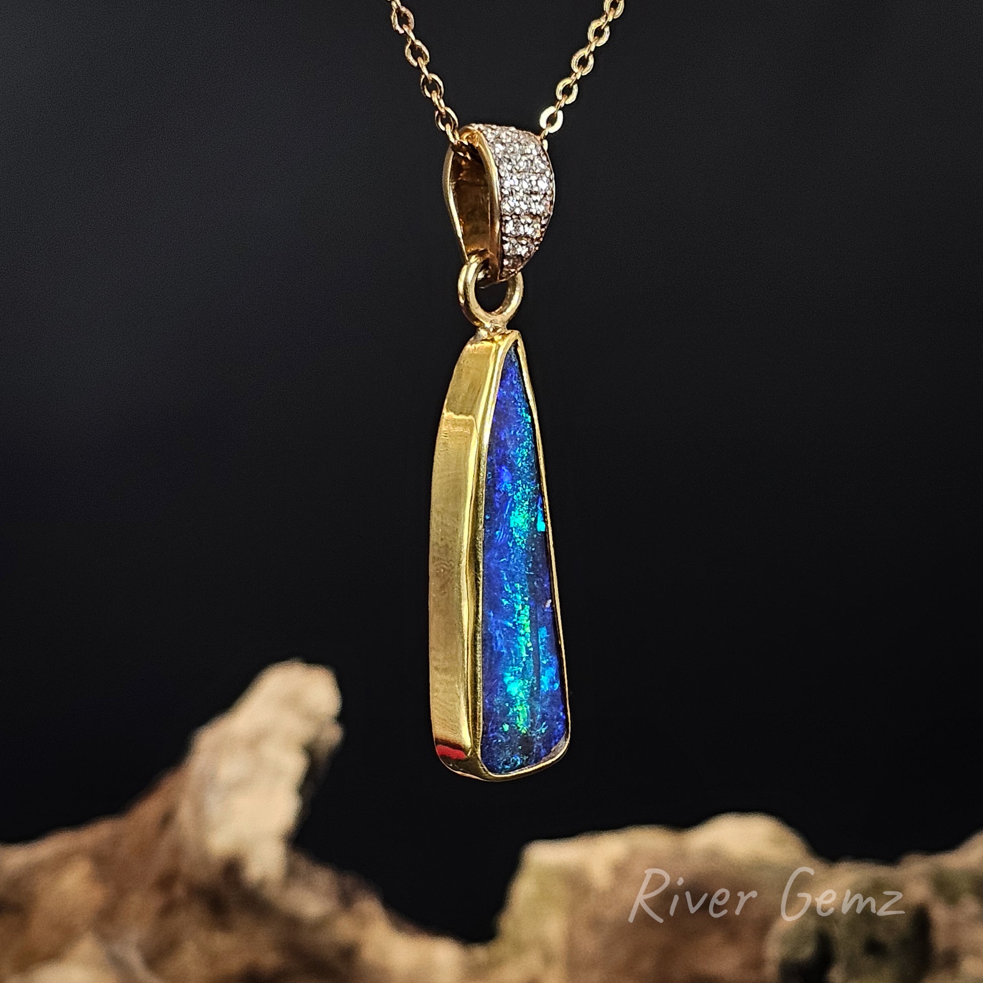 Opal pendant necklace with gold frame on a dark background, featuring 'River Gemz' branding.
