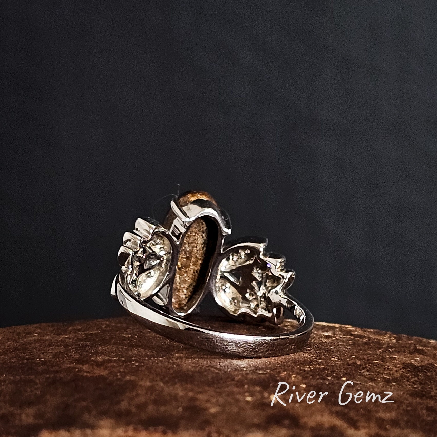 Rear of white gold ring with embedded boulder opal on a dark background, featuring 'River Gemz' branding.