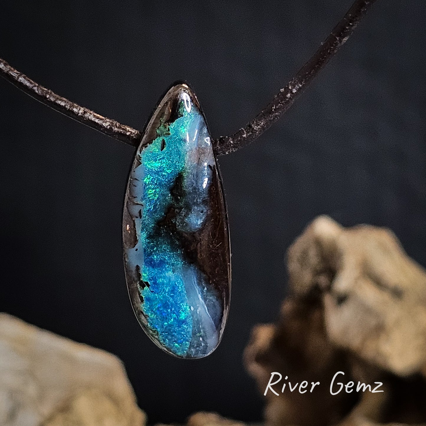 Blue and green boulder opal drilled through to pass the leather necklet through.