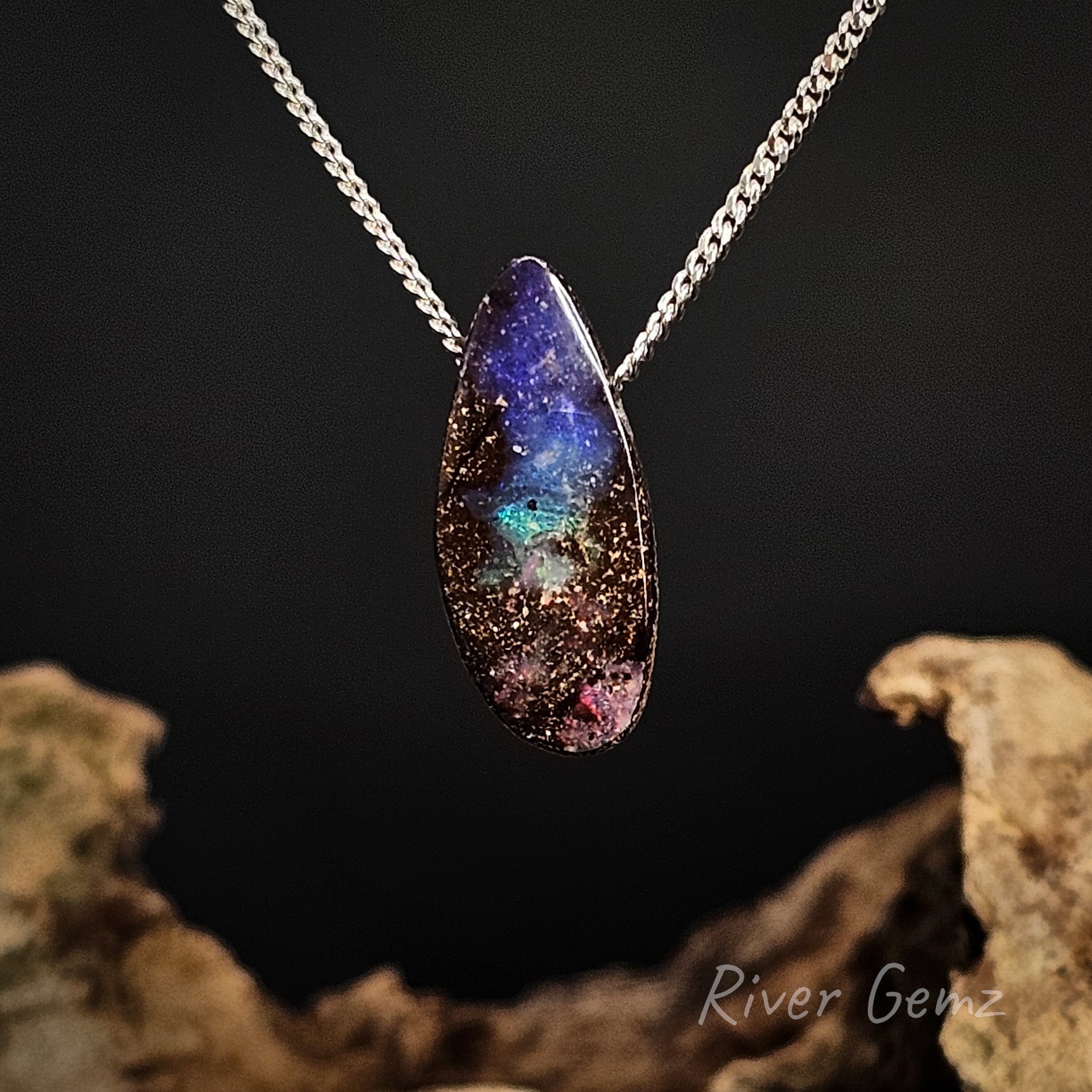 Necklace with a colorful boulder opal on a dark background