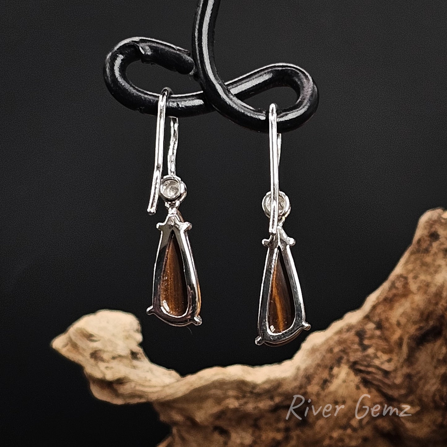 Rear view of silver shepherd hooks shows the ironstone base of the boulder opals.