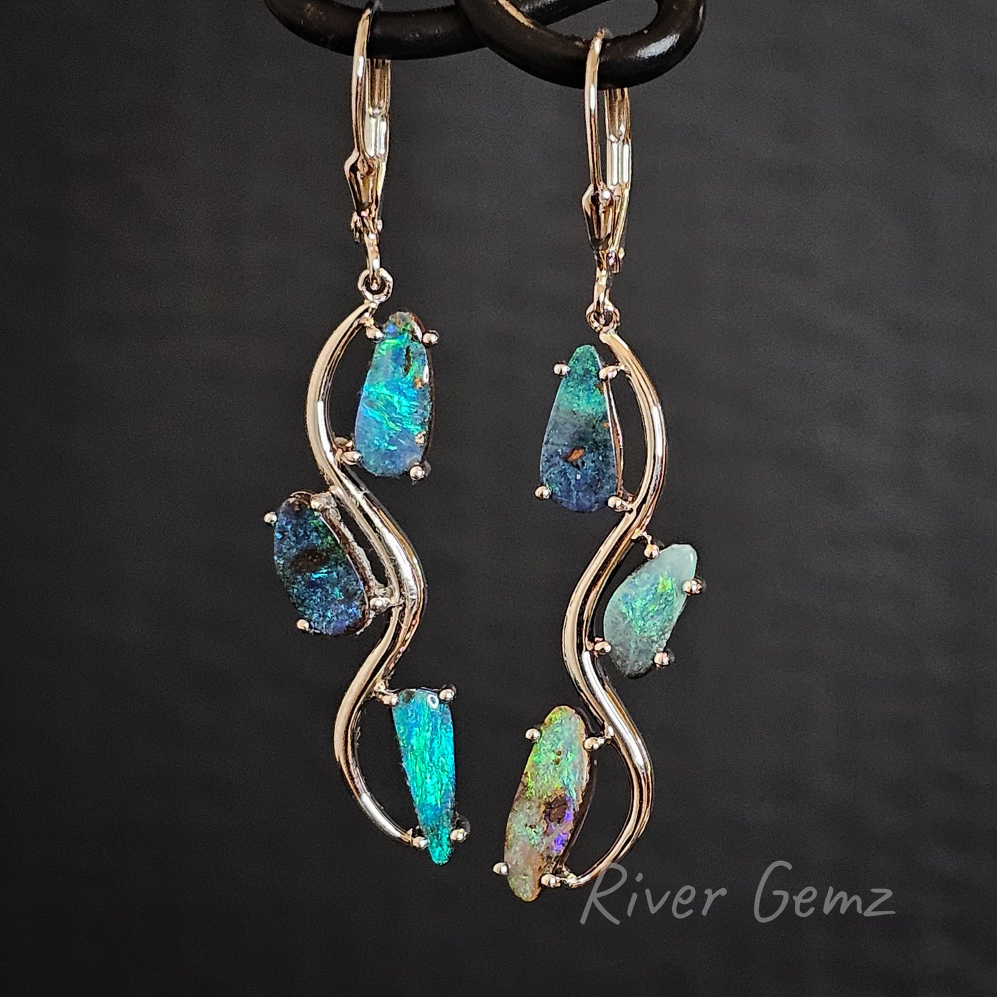 3 boulder opals claw set in silver hook earrings with continental clasps.