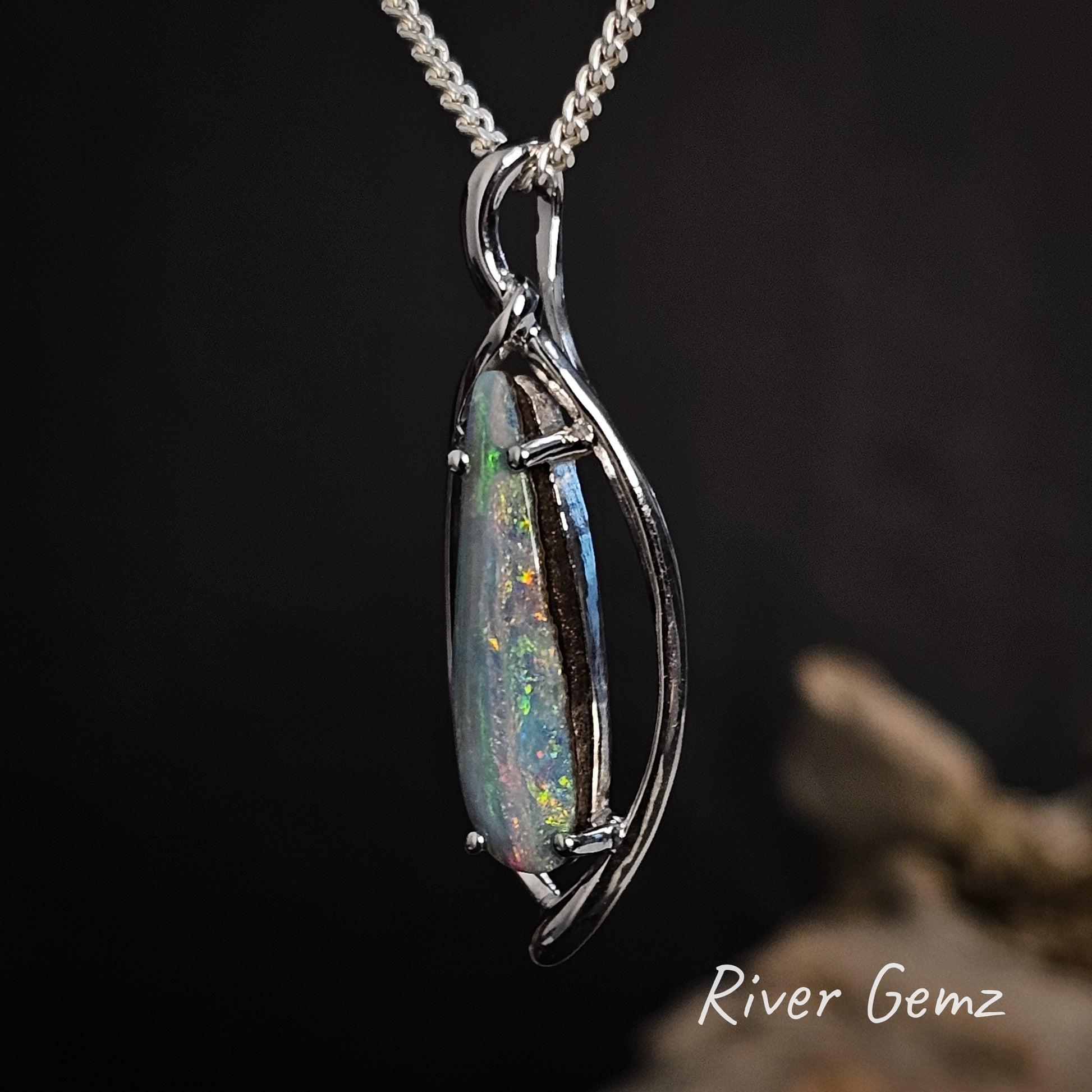 Side view shows the size of the bail eyelet clearly. Colourful boulder opal claw set in the necklace.