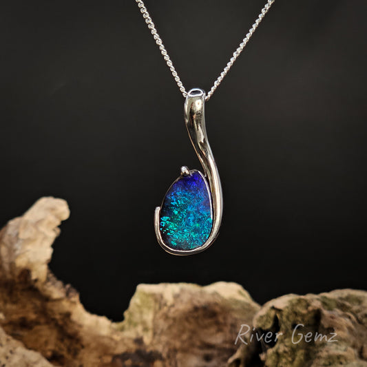 Blue pendant necklace on a dark background with 'River Gemz' branding.