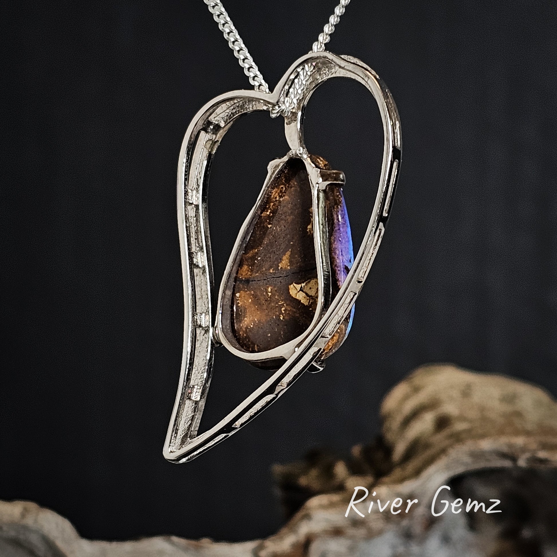 Rear of silver pendant shows the ironstone matrix of the embedded boulder opal on a dark background, featuring 'River Gemz' branding.