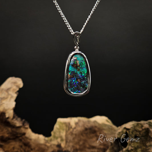 Necklace with a colorful boulder opal set in sterling silver on a dark background