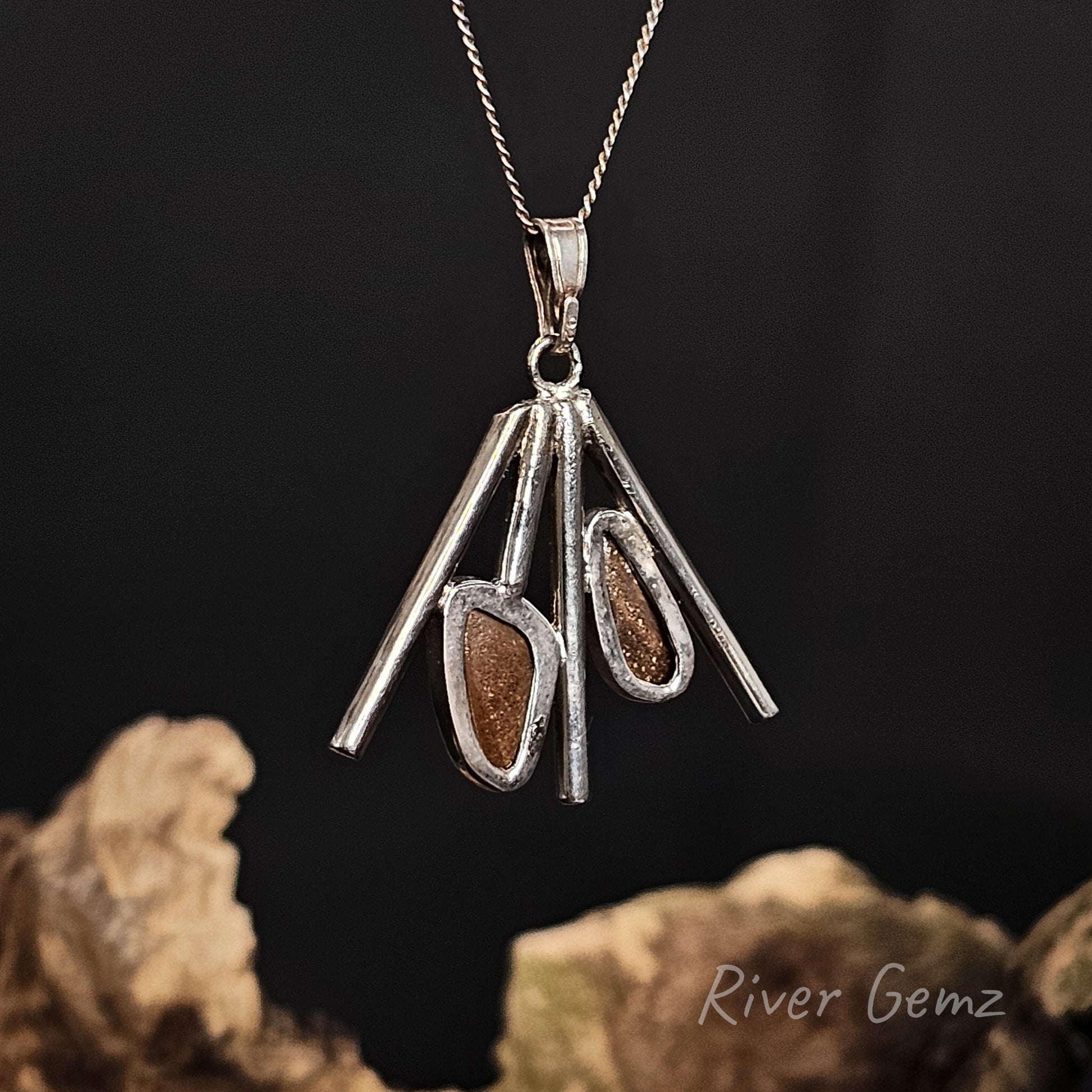 Back view of the silver pendant shows the ironstone matrix base of the boulder opals on a dark background, featuring 'River Gemz' branding.