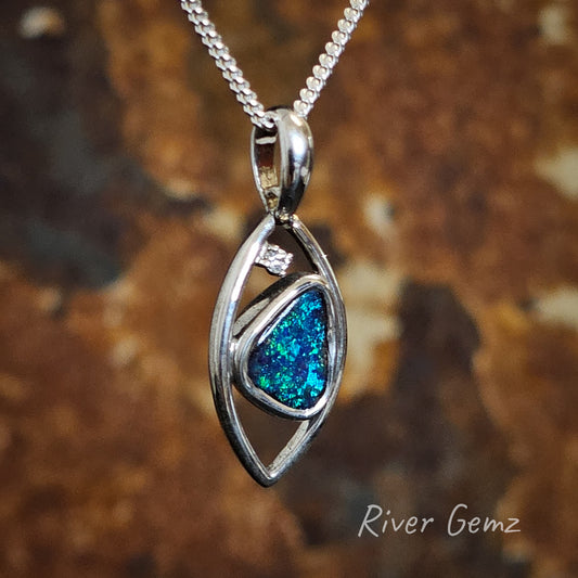 Leaf shaped silver pendant with triangular shaped dark blue and green opal integrated and white topaz stone.