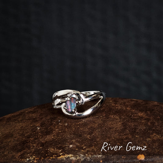 Silver ring with a multi-coloured opal stone on a dark background, branded 'River Gemz'.