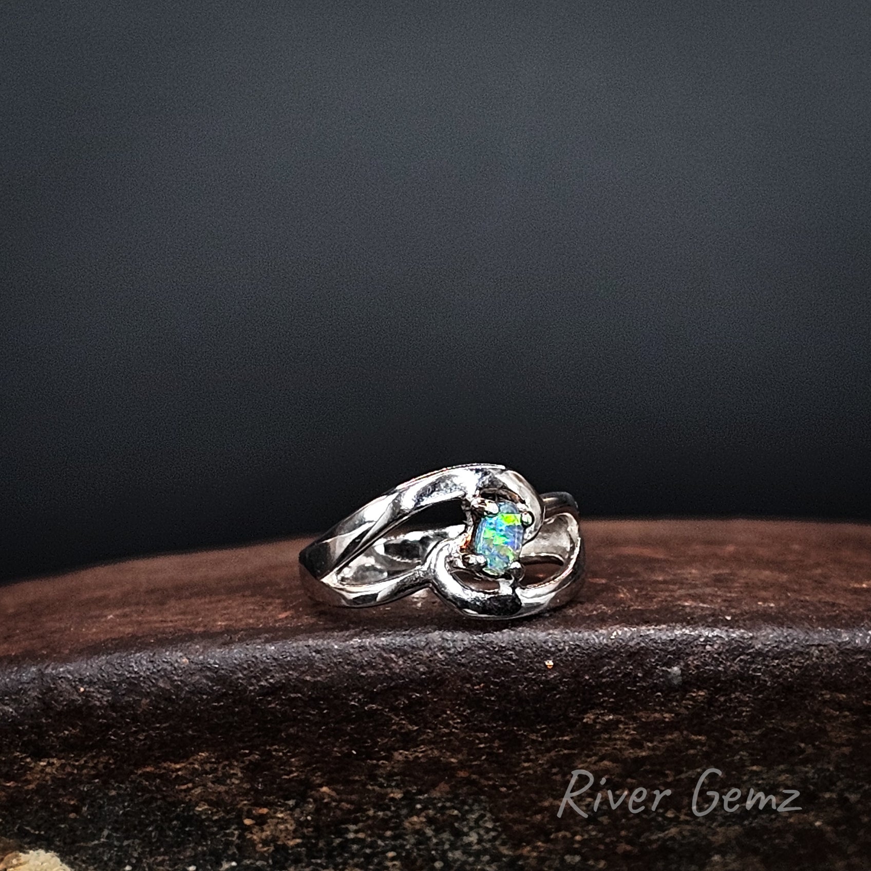 Oval shaped boulder opal claw set in sterling silver ring.