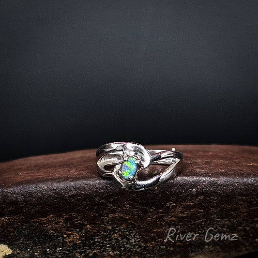 Green and blue boulder opal claw set in silver ring.