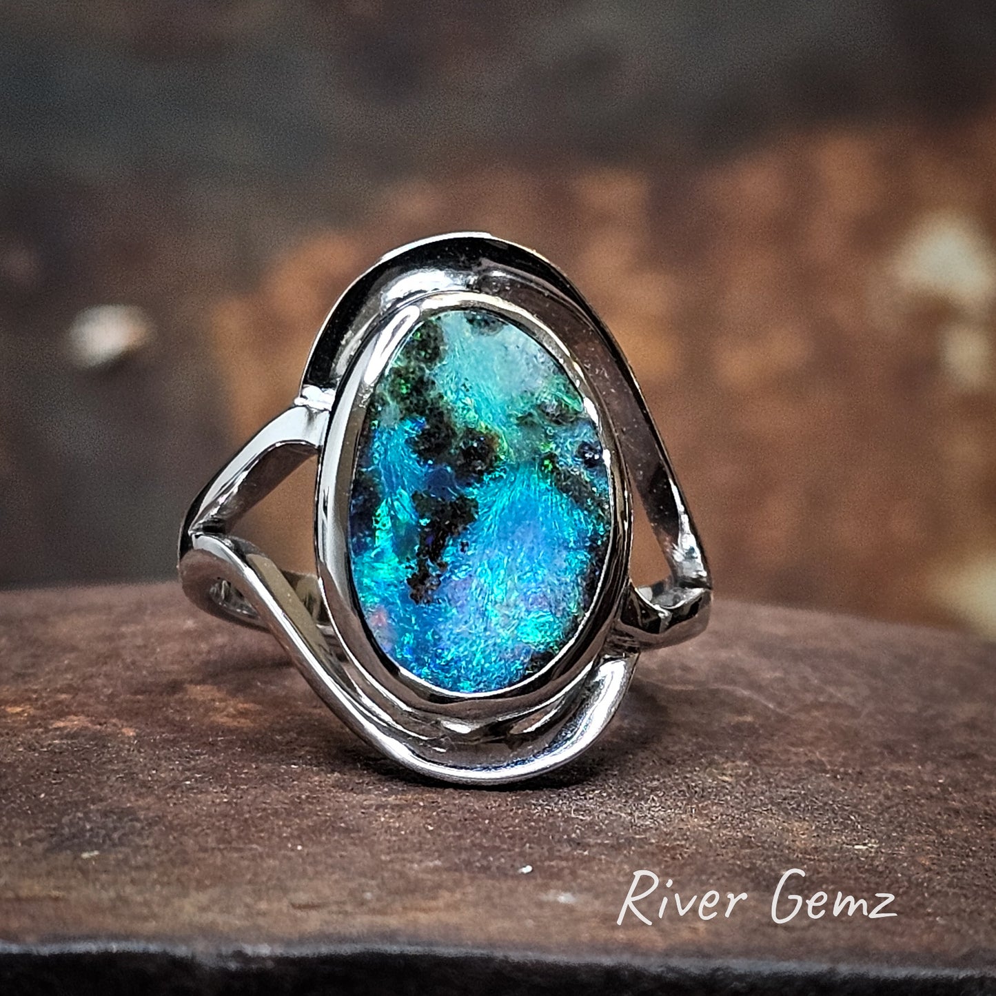 Large oval shaped colourful boulder opal set in silver ring.