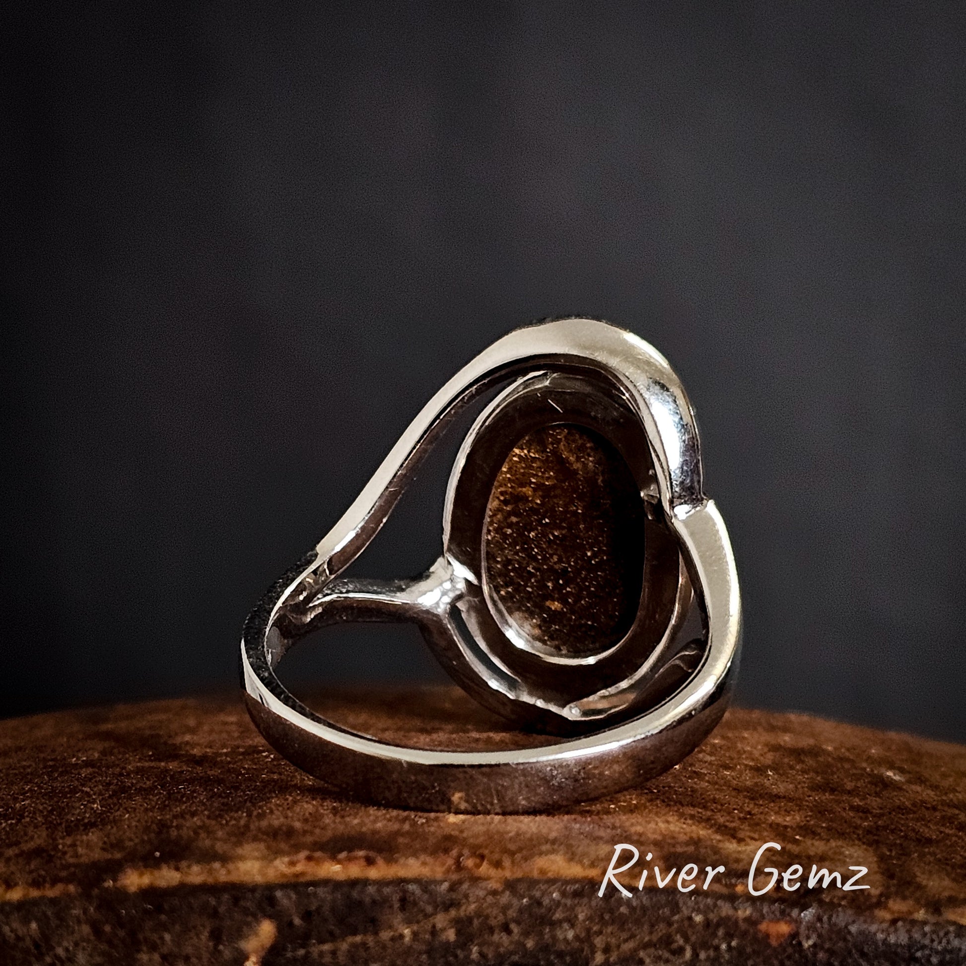 Back of the silver ring with the brown ironstone body of the boulder opal showing on a dark background, branded 'River Gemz'.