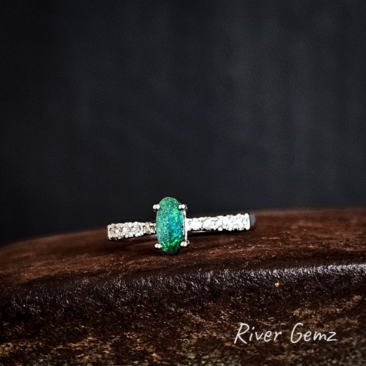 Silver ring with a green dark opal and white topaz shoulders on a dark background, branded 'River Gemz'.