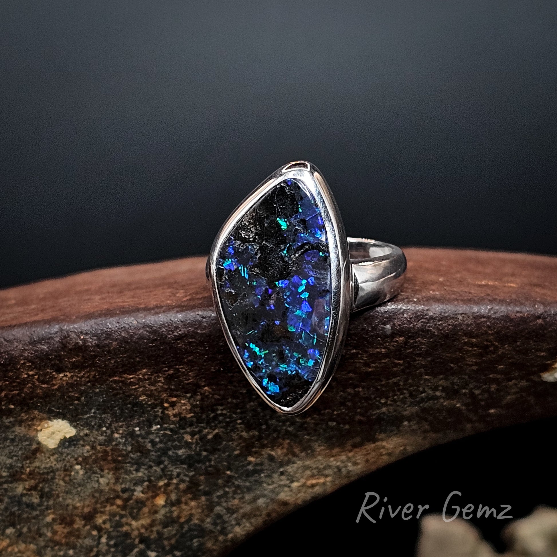 Large blue and purple dark opal besel set in silver ring.