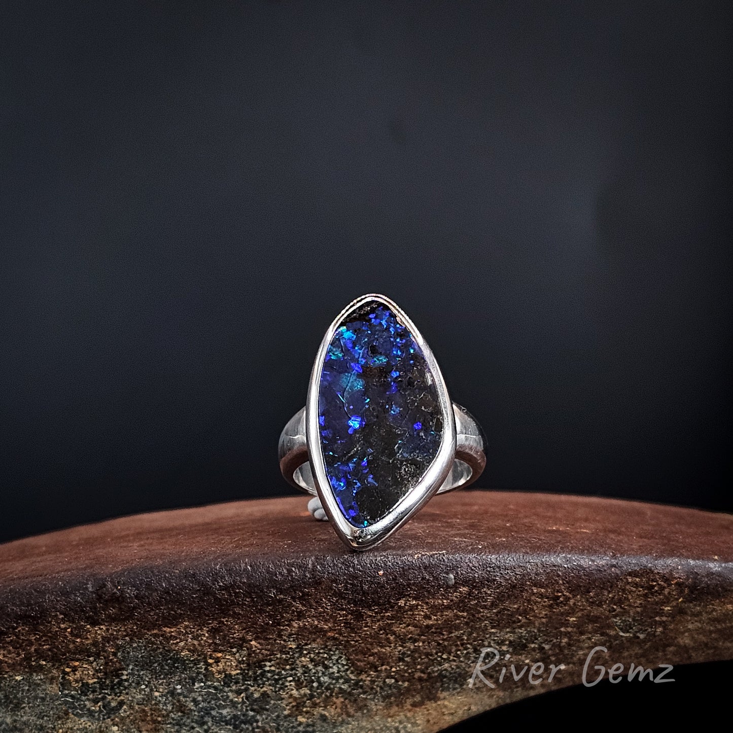 Blue and purple boulder opal besel set in large sterling silver ring.