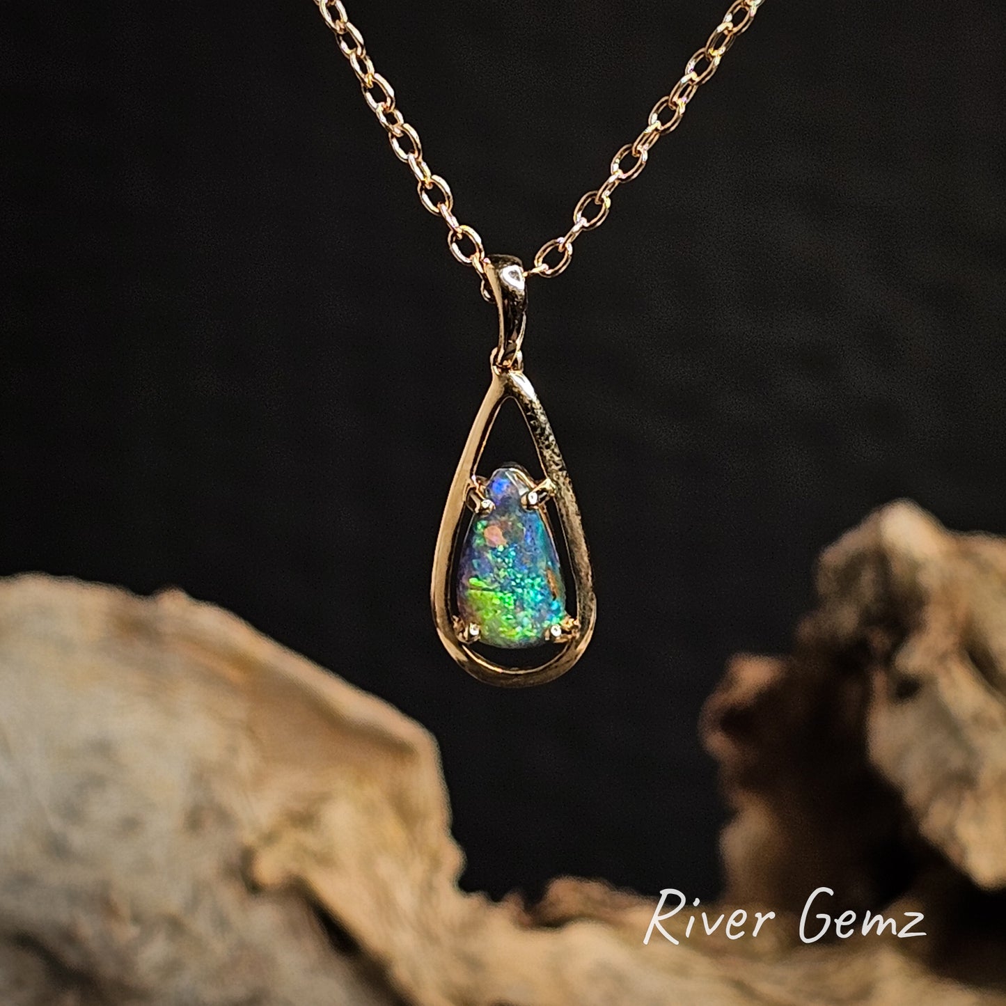 Blue and green opal pendant necklace on a chain with a dark background and 'River Gemz' branding.