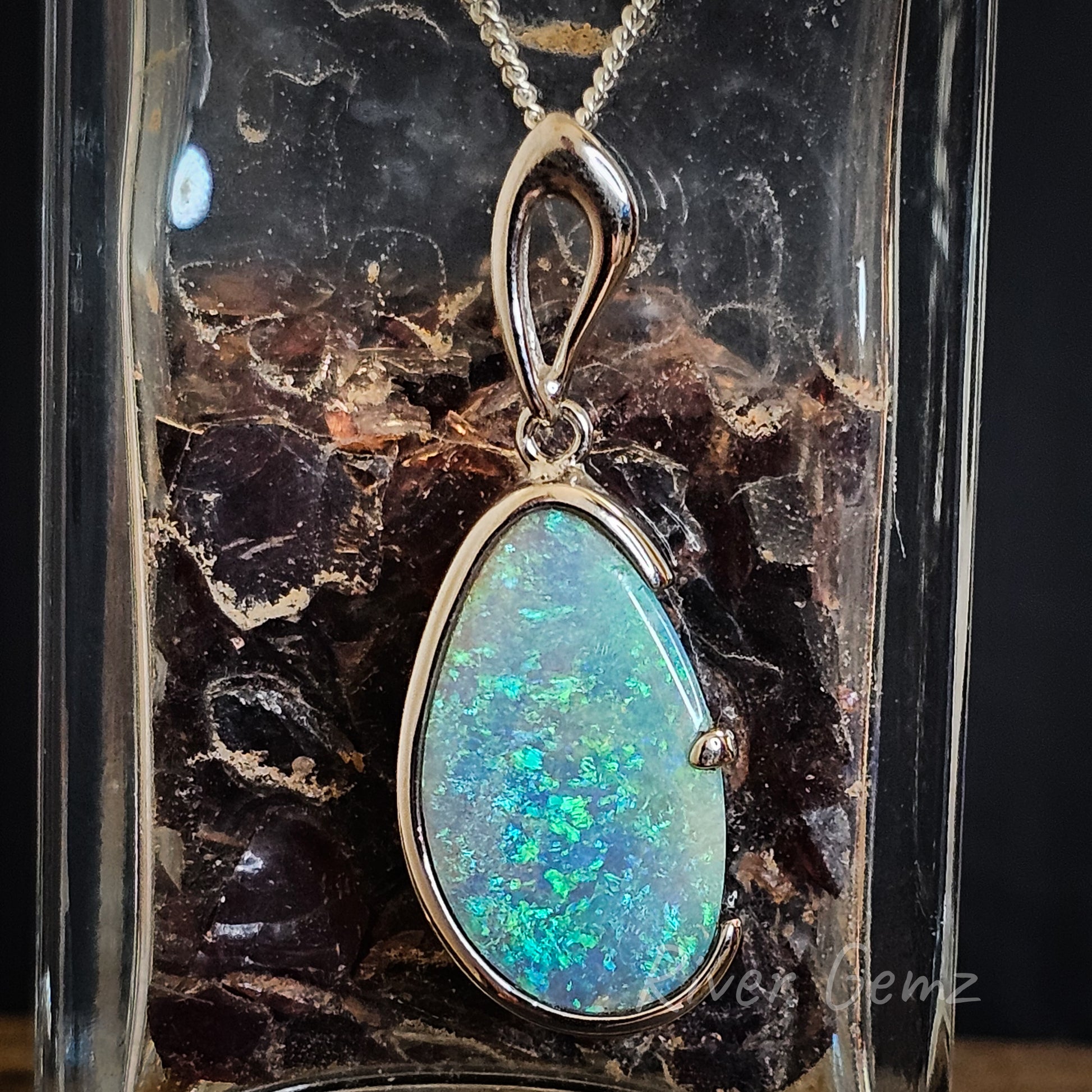 Oval shaped blue green opal in sterling silver pendant with large bail.