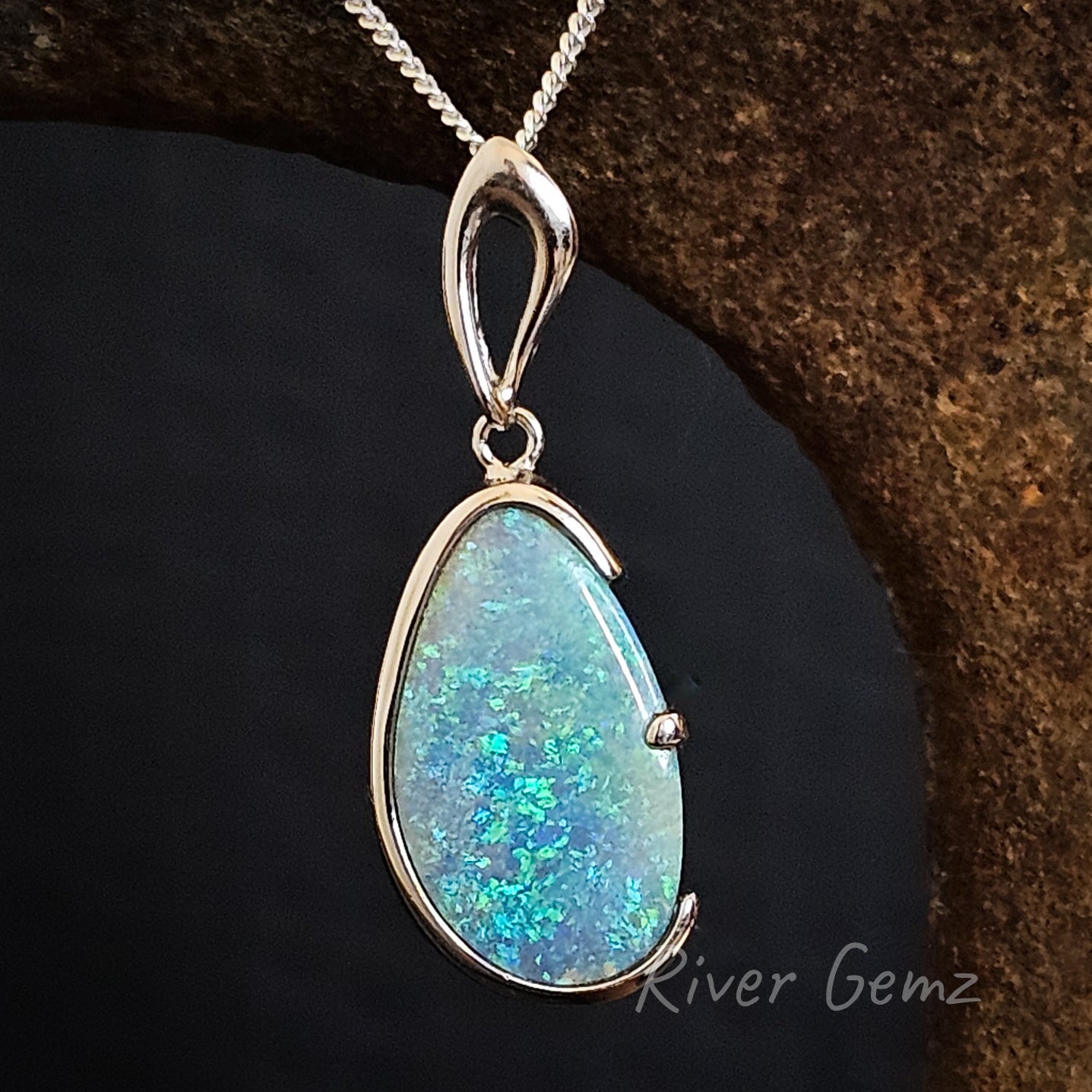 Vibrant blue and green boulder crystal opal in a modern style silver necklace.