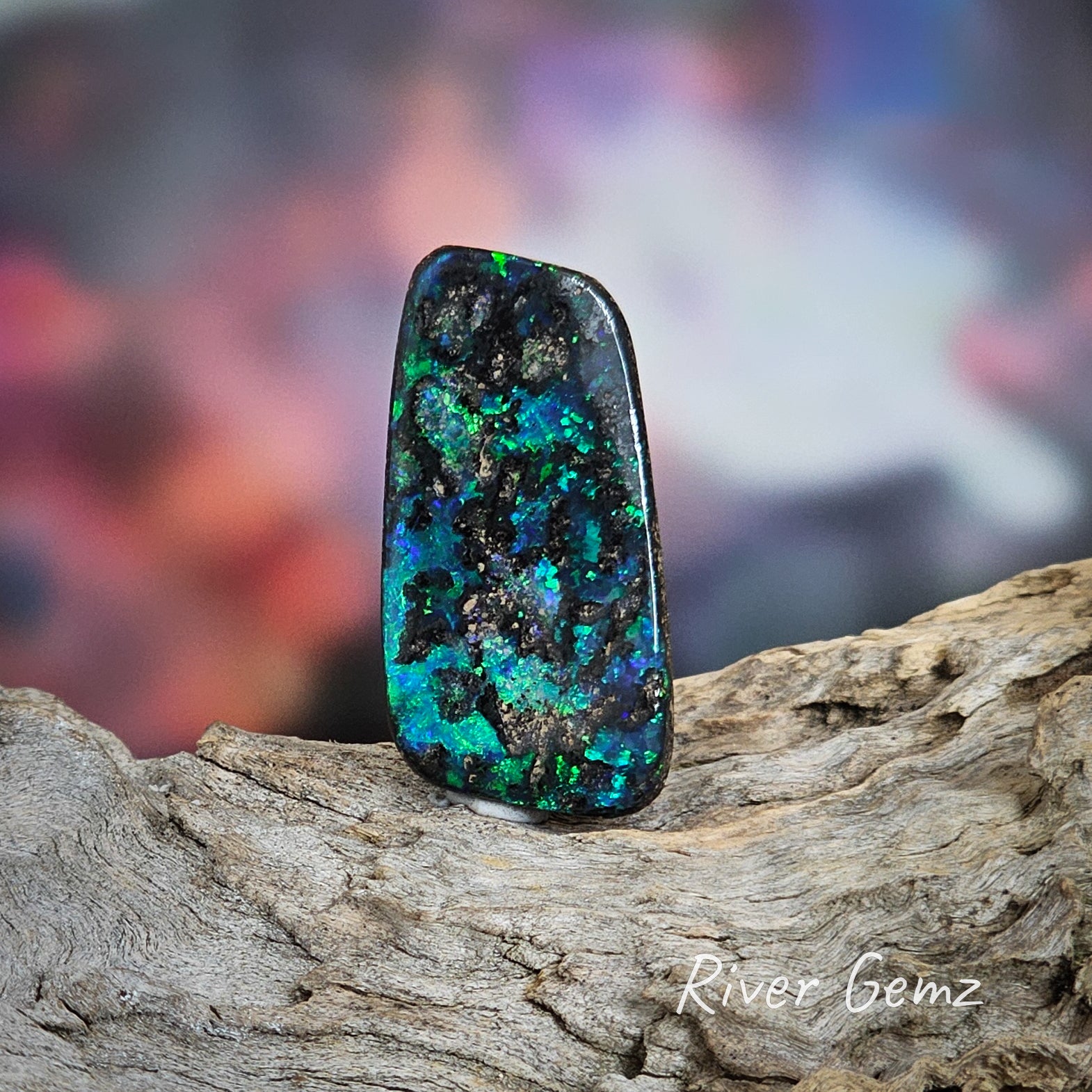 Dark blue and green patches of colour on dark ironstone in this unset boulder opal.