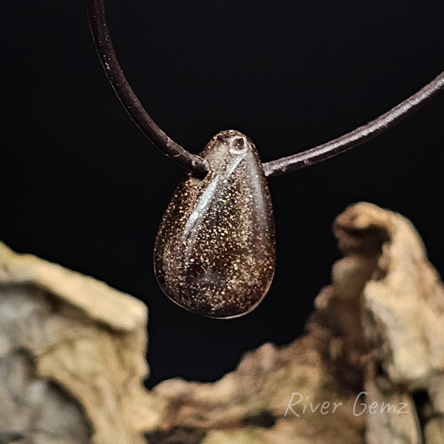 Rear view of the teardrop-shaped boulder opal pendant on a dark background with 'River Gemz' branding.