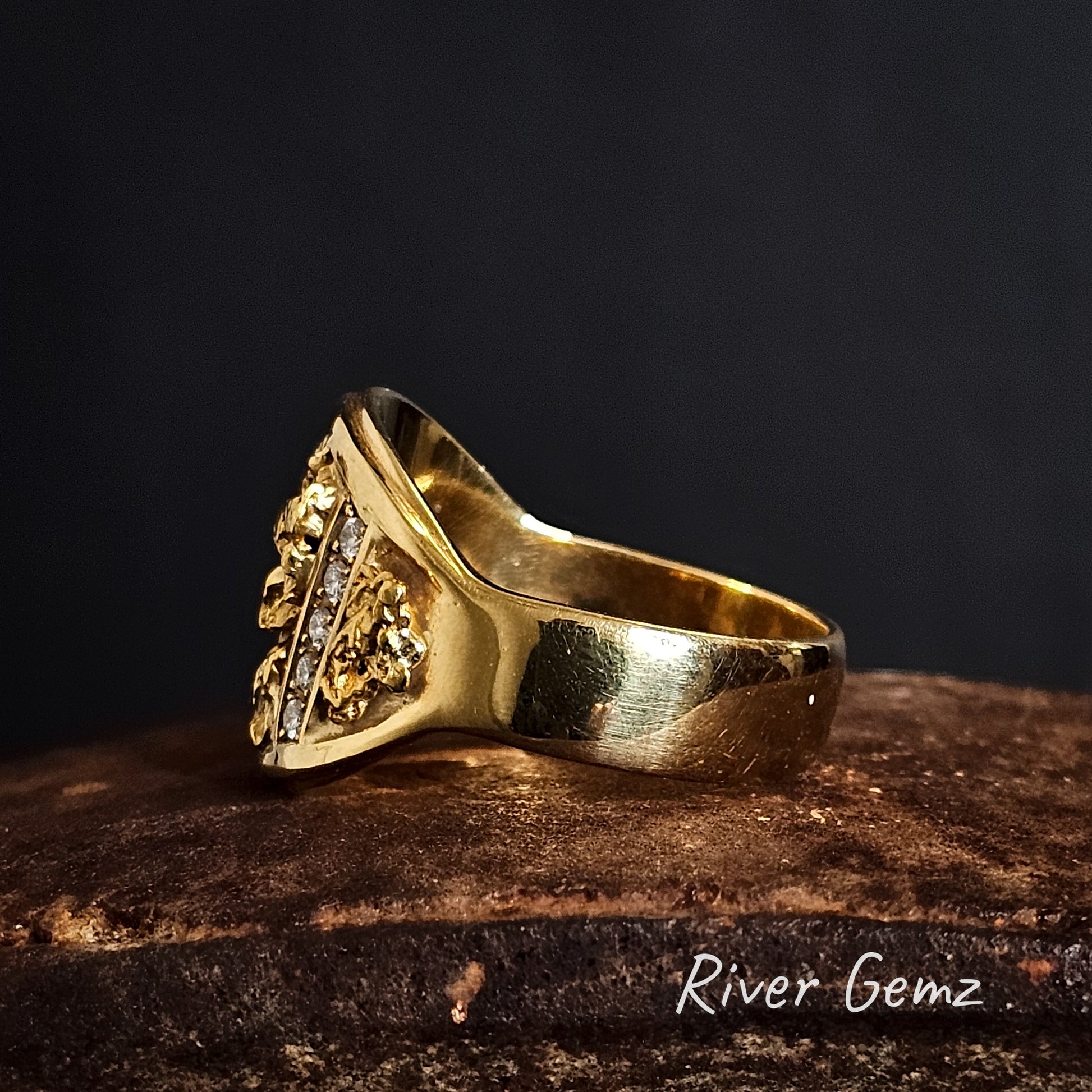 Side view of gold nuggets and diamonds ring with intricate design on a dark background.