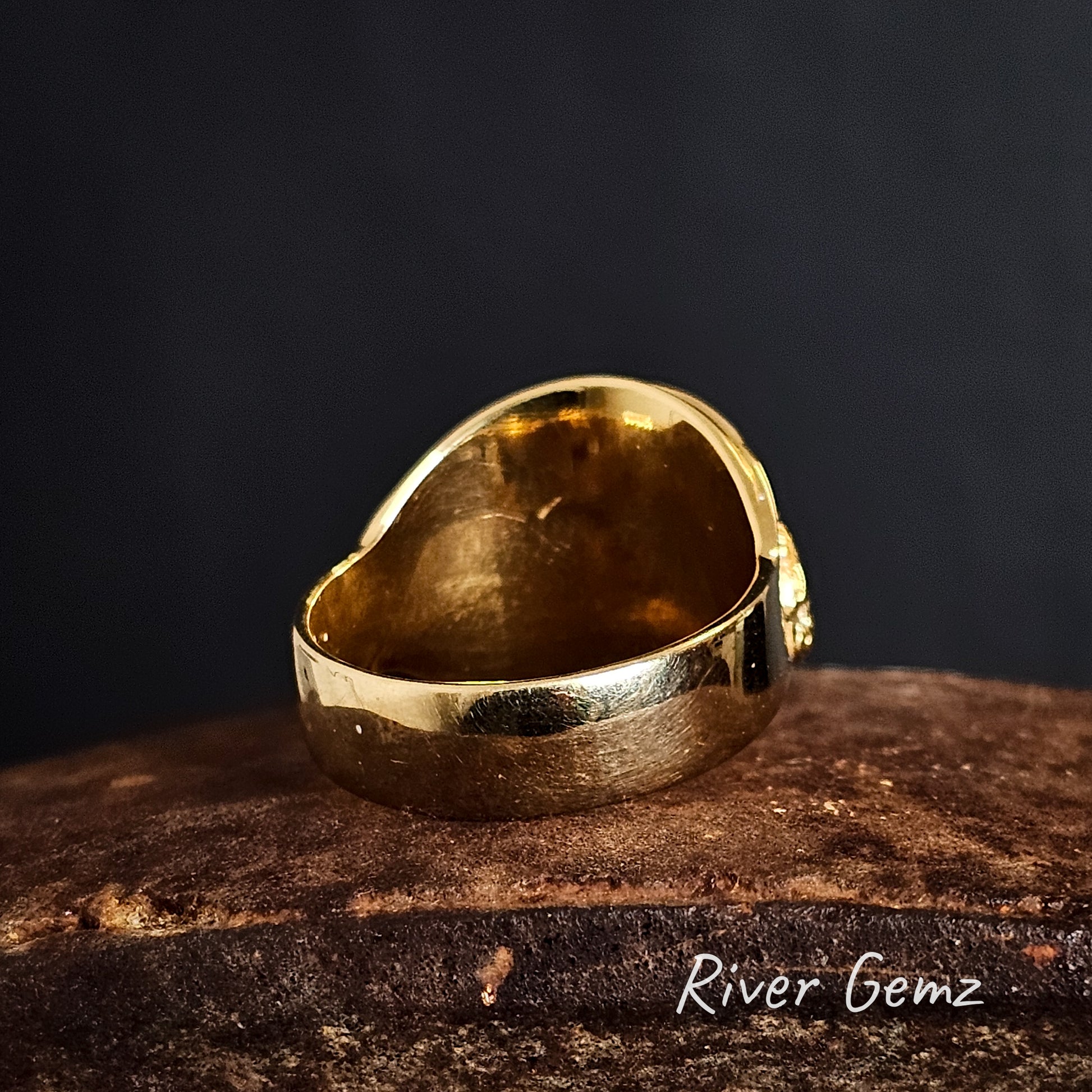 Rear view of gold ring on a dark background with 'River Gemz' branding.