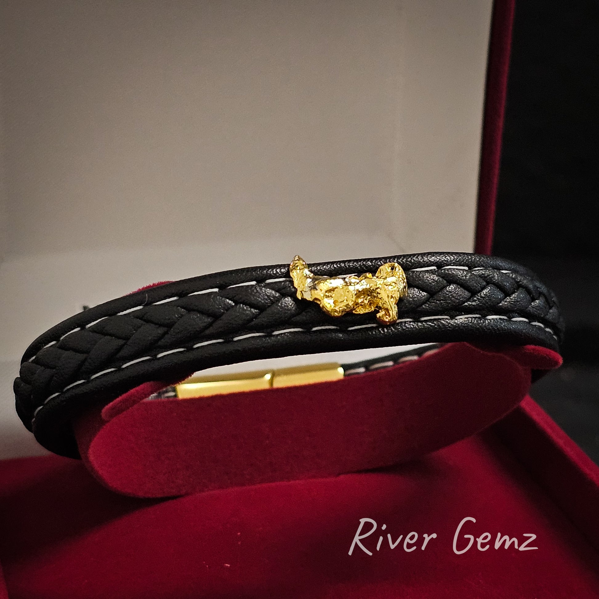 Gold nugget leather bracelet shown in red velvet display box.