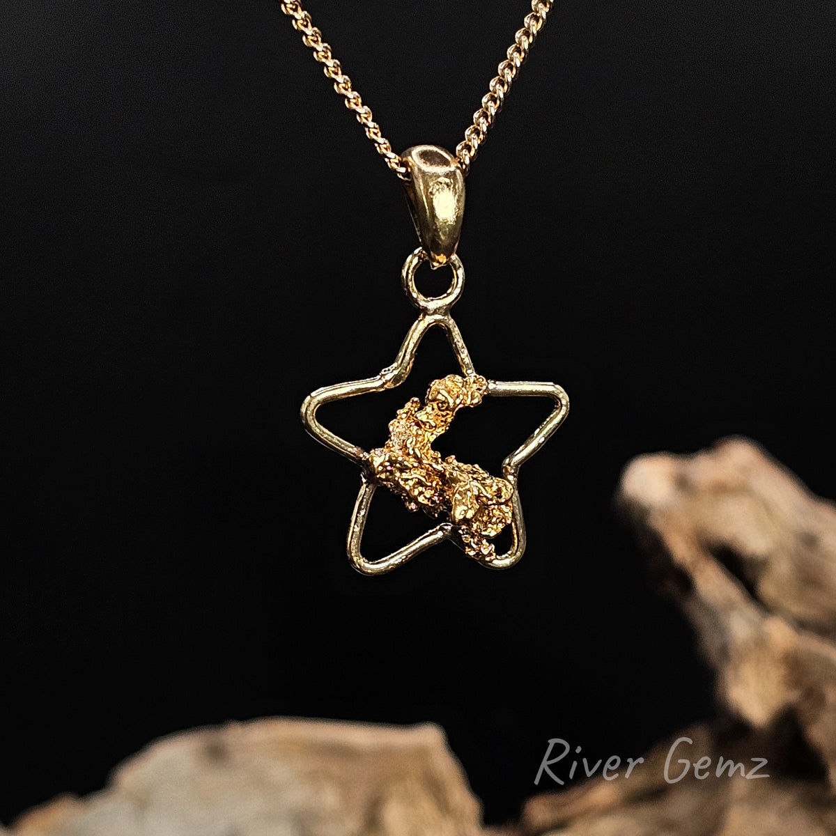 Natural gold nugget in a star shaped necklace against a black background and 'River Gemz' water mark in the bottom right hand corner.