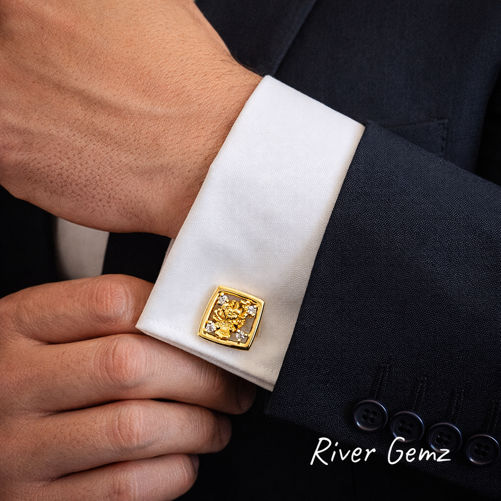 Gold cufflink on a white cuff of a suit with 'River Gemz' branding.
