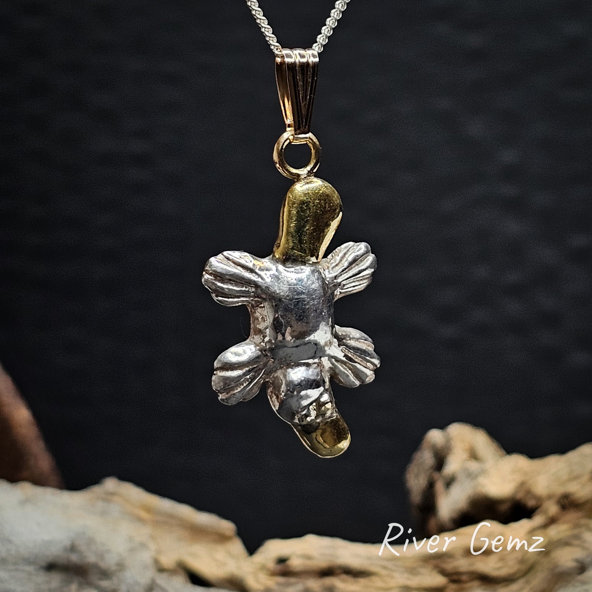 Platypus pendant with silver body and gold tail and bill.