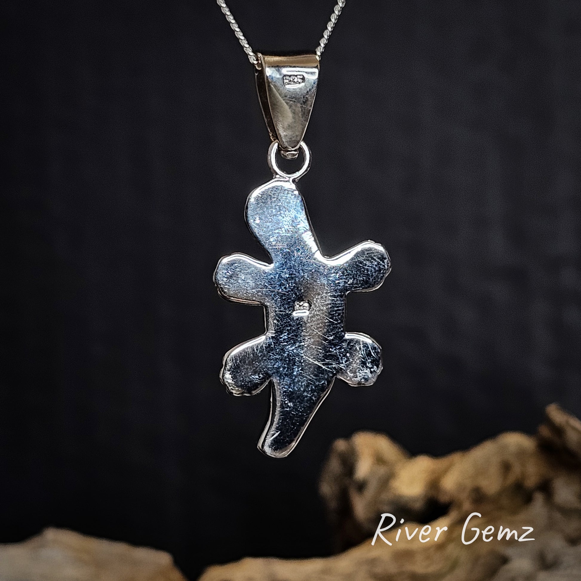 Back of silver pendant on a chain with a dark background and 'River Gemz' branding.