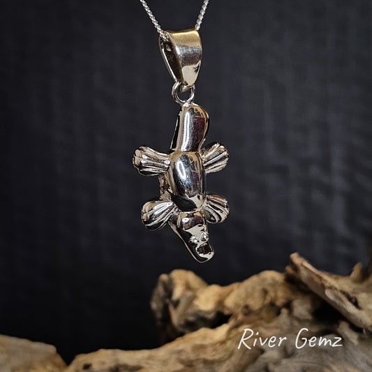 Silver platypus pendant on a dark background with 'River Gemz' branding.