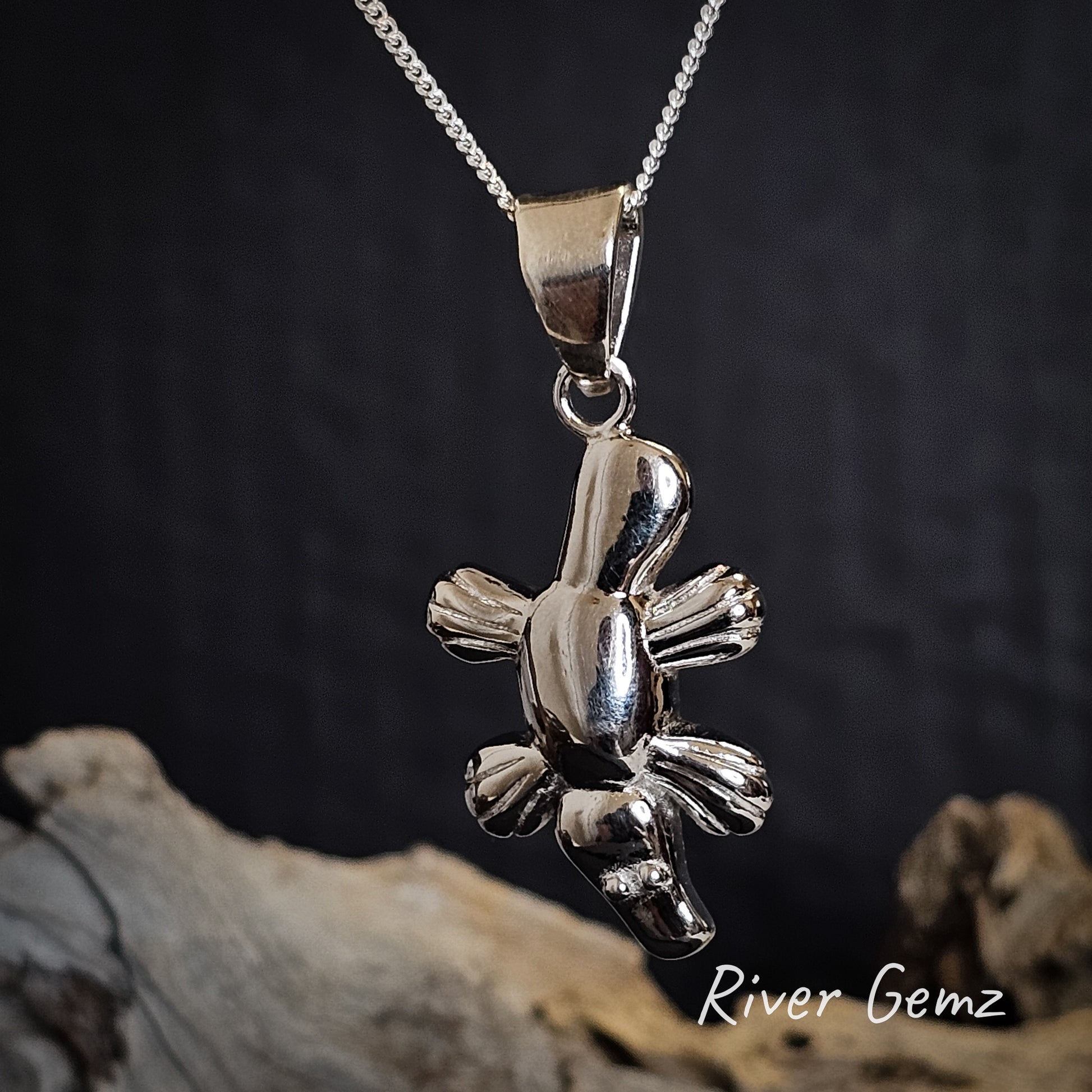 Silver platypus pendant with large bail on a chain with a dark background