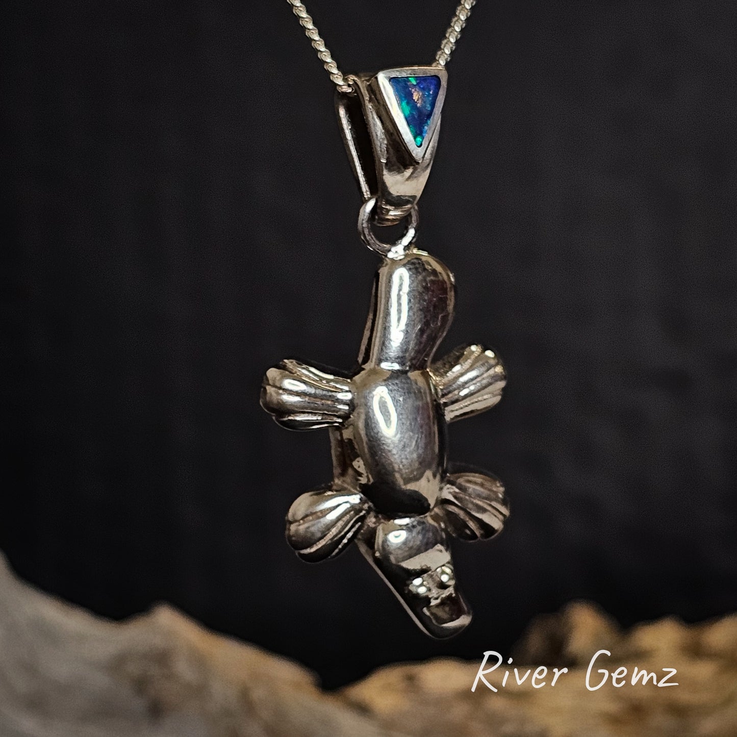 Silver platypus pendant with a triangular shaped blue and green Australian opal in the bail.