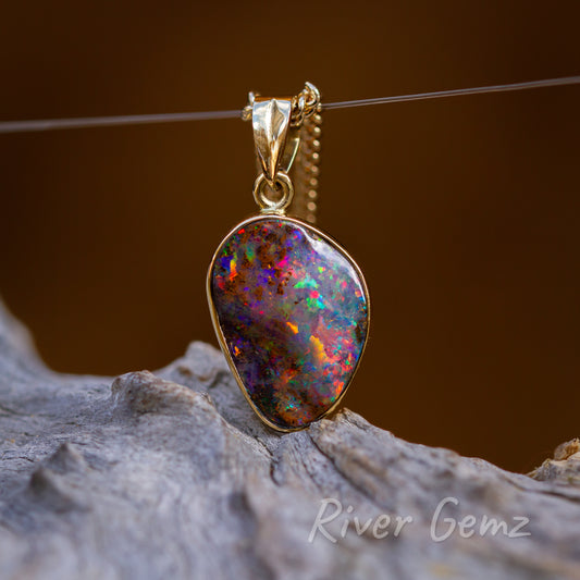 Approximately oval shaped opal with extraordinary colours. Bezel set in yellow gold with eyelet at the top where the bail connects.