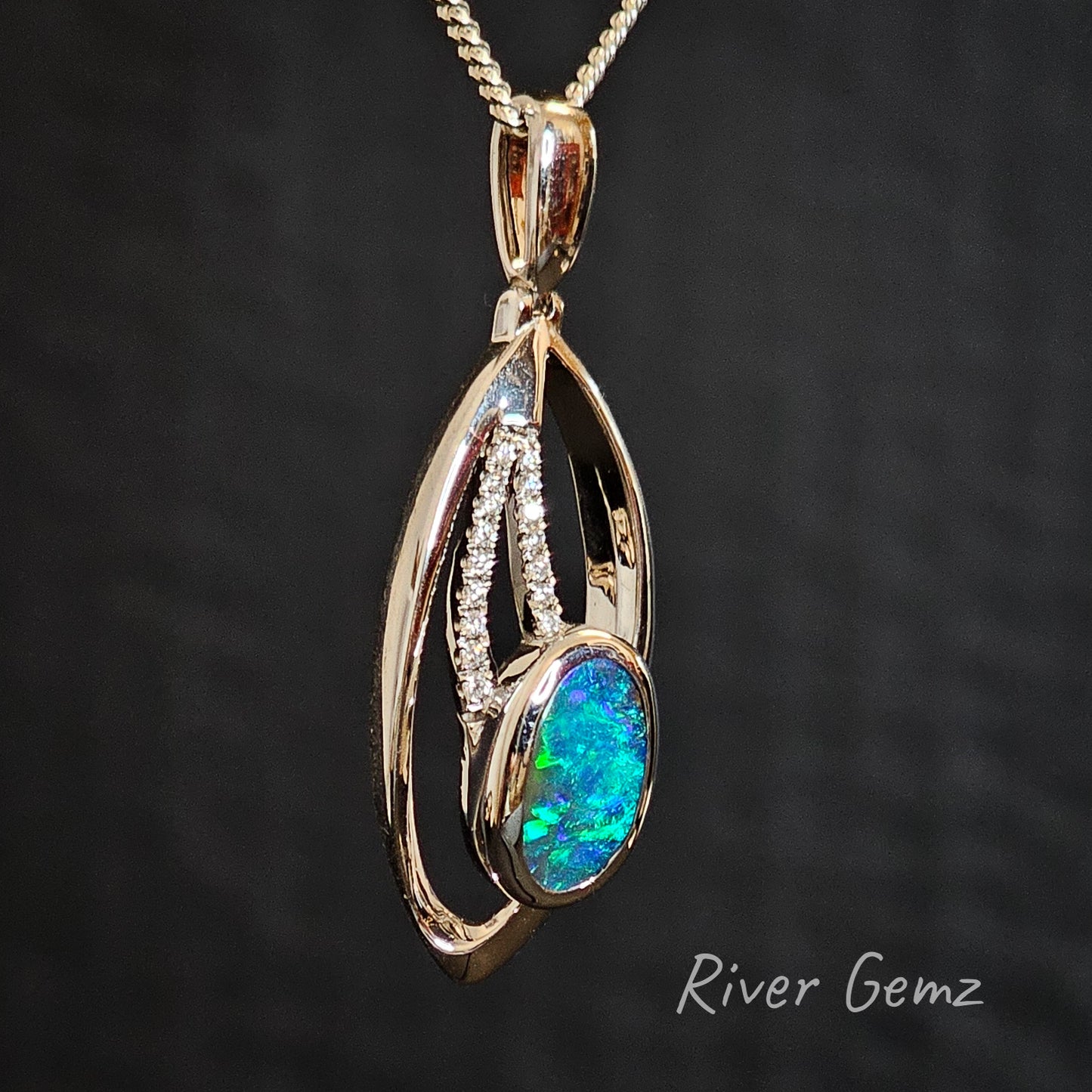 Slightly side on view of the white gold, boulder opal and diamonds necklace showing the size of the bail clearly.