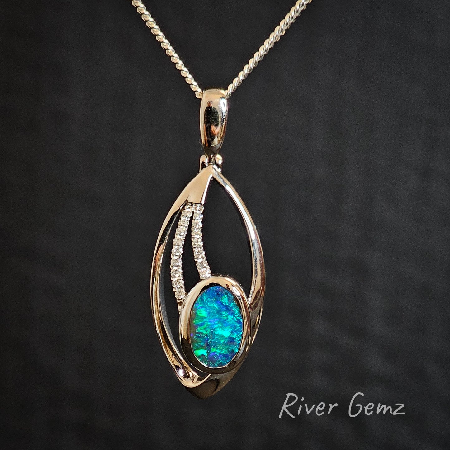 Blue and green boulder opal set in high grade white gold necklace with two lines of diamonds included.